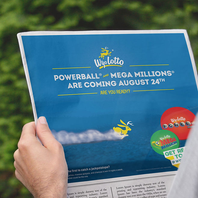 Person holding newspaper with ad for wyolotto